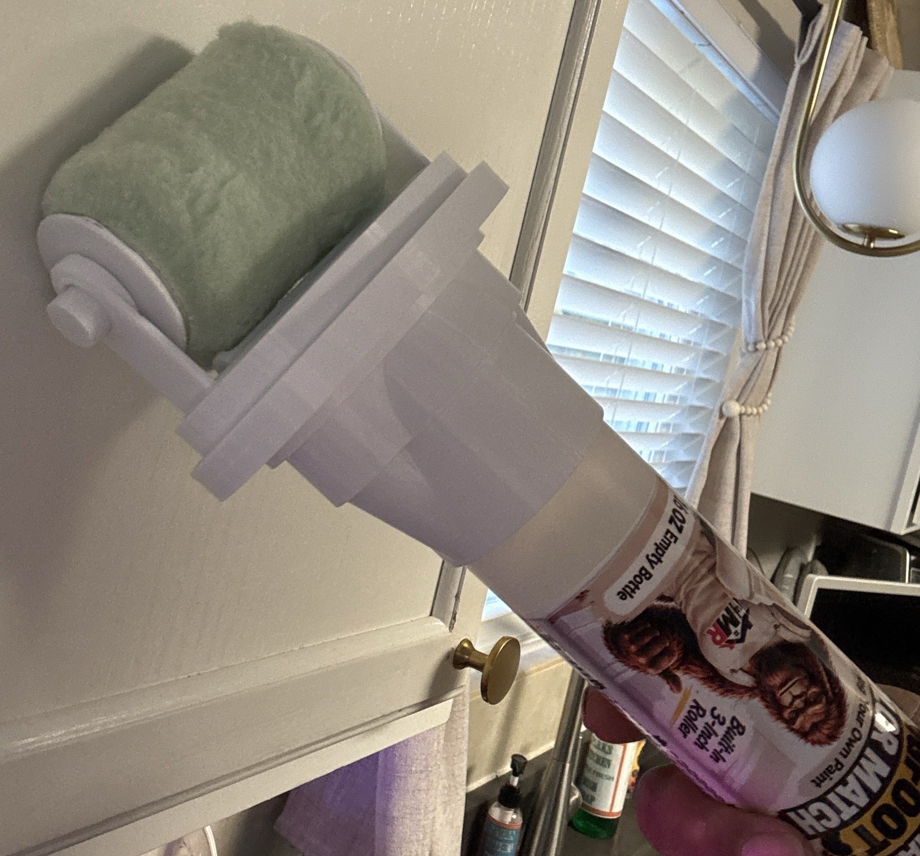Mr. Brushable BIGFOOT bottle with its 3-inch roller held against a cabinet